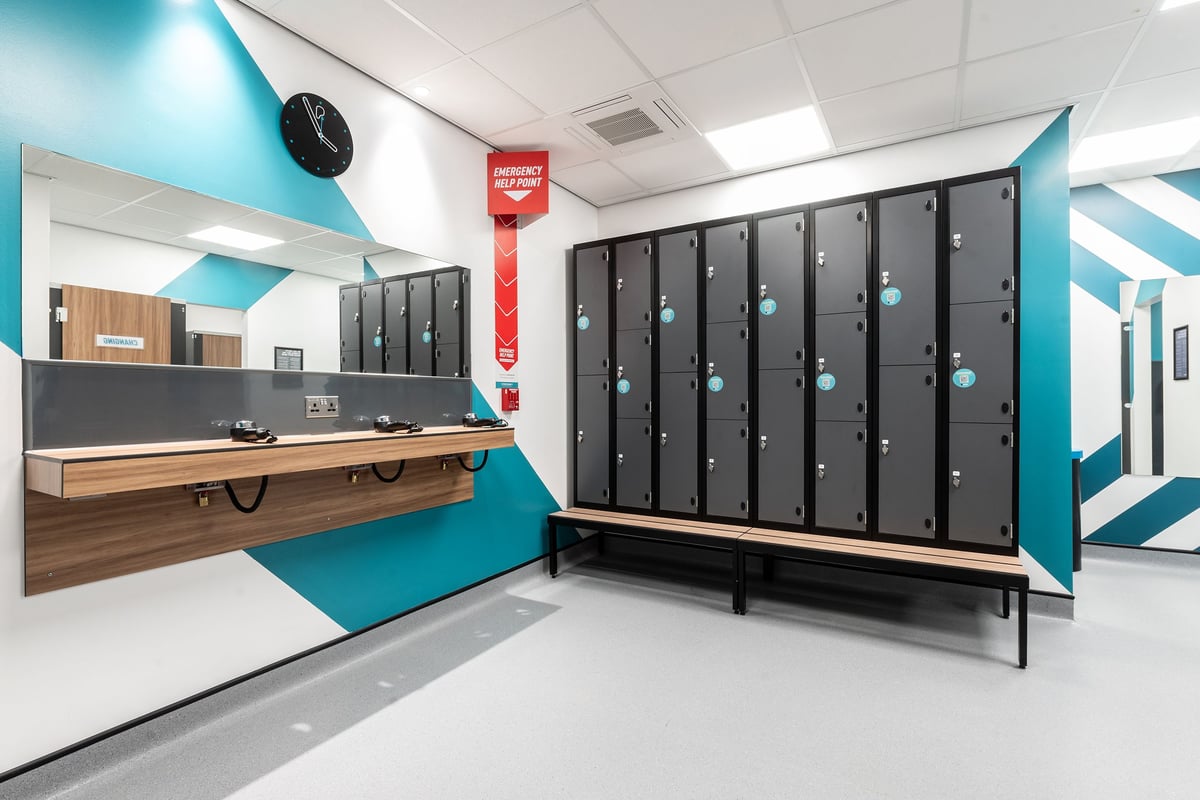 PureGym Coalville: Rows of lockers, changing benches in wood and teal decor.