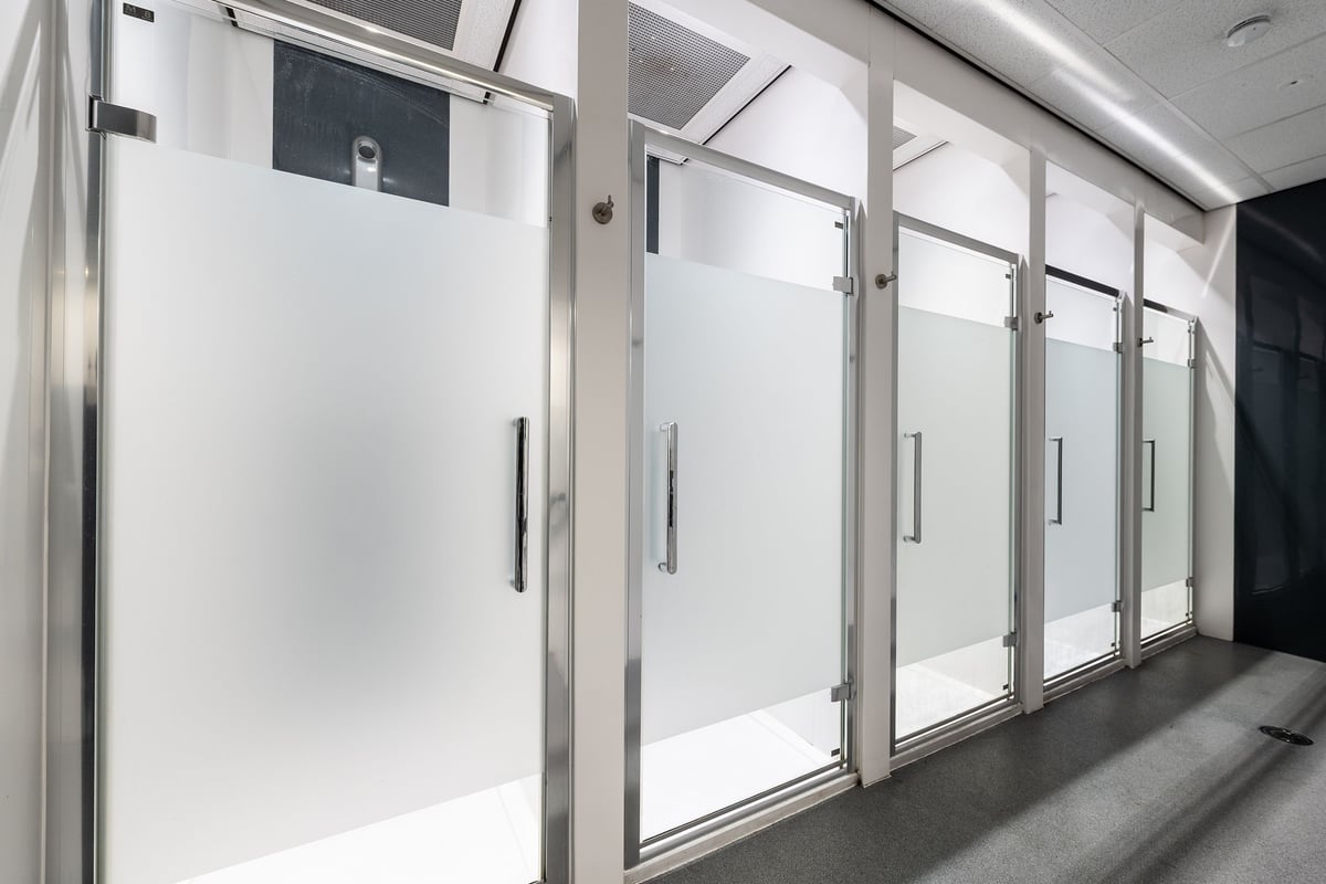 PureGym Manchester Cheetham Hill Retail Park: Rows of upright full-length lockers or changing room stalls with doors.