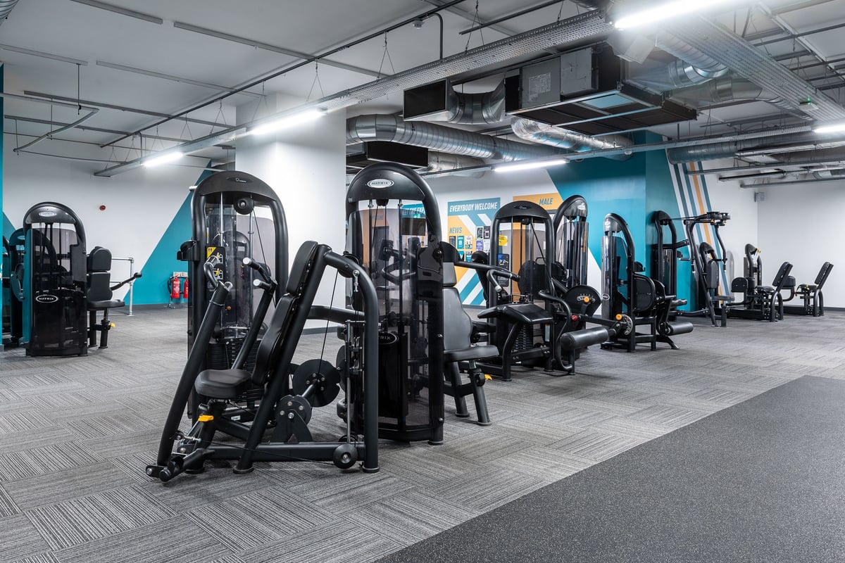 PureGym Stevenage: Gym room with resistance machines, weight stacks, benches, and mirrored walls.
