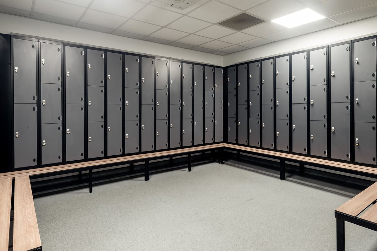 PureGym Leicester St Georges Way: Rows of lockers along curved benches in a changing room setting.