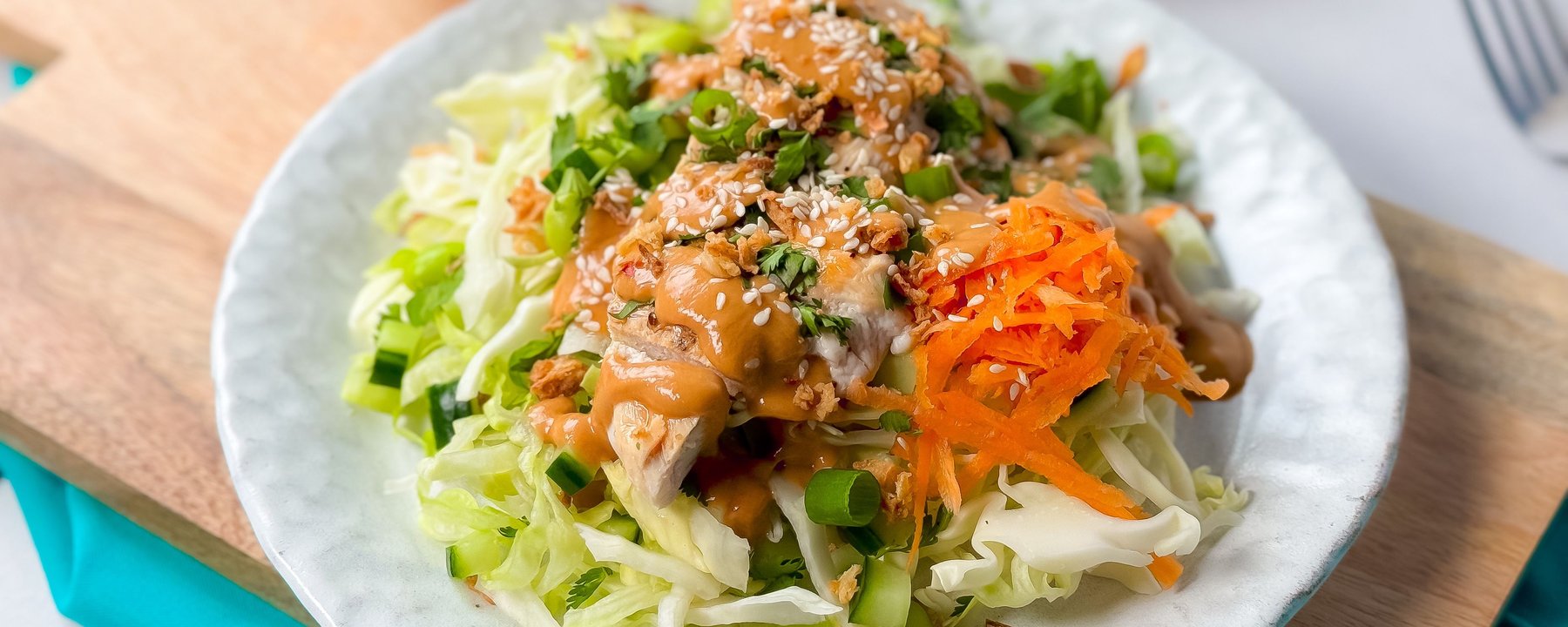 Grilled chicken with sesame seeds and peanut sauce on shredded cabbage and carrot