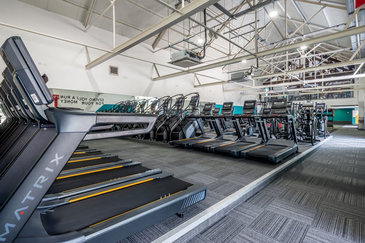 PureGym Northwich: Rows of treadmills and other cardio machines in a brightly lit gym interior.