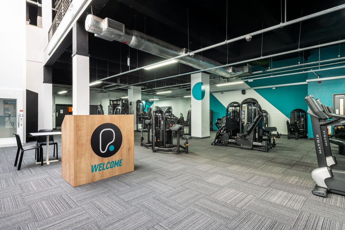 PureGym Manchester Market Street: Gym studio with resistance machines, free weights, benches, and mirrored walls.