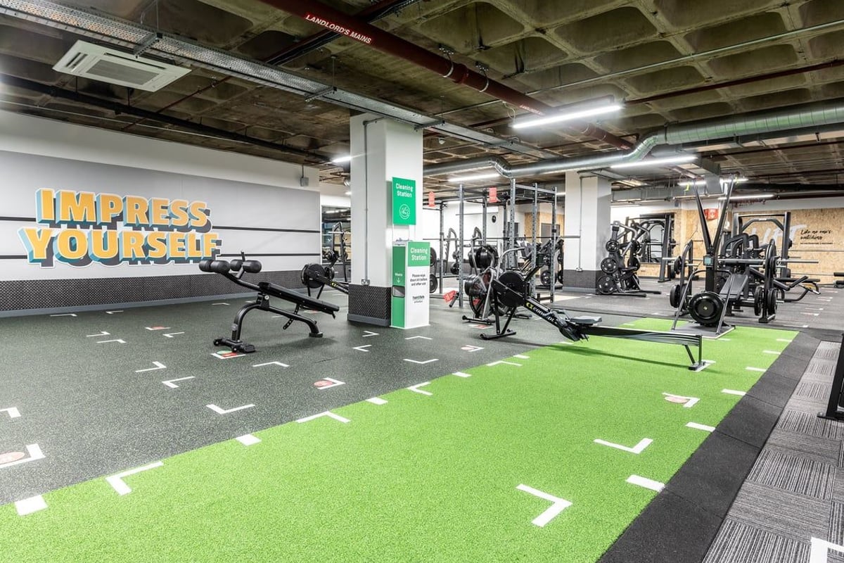 PureGym Maidstone The Mall: Weightlifting area with racks, free weights, green turf, and motivational mural on the wall.
