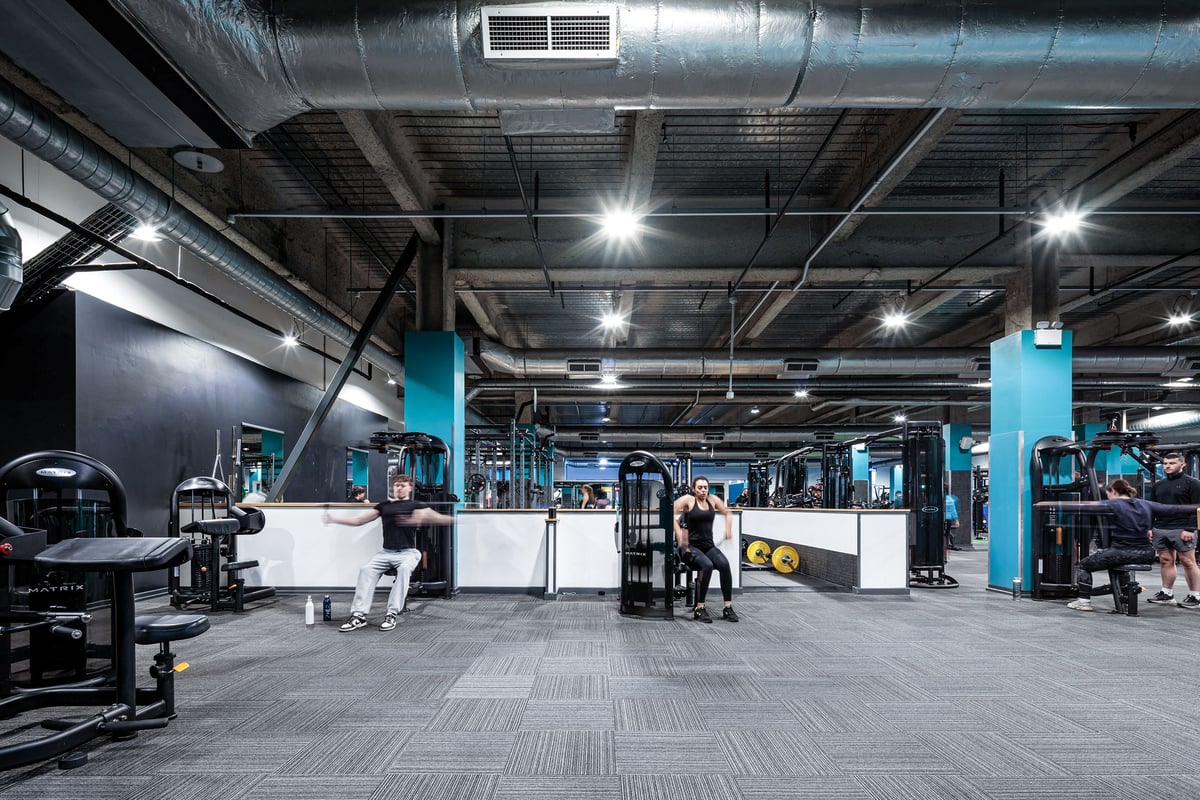 PureGym Cardiff Central: Gym studio with cable machines, free weights, benches, and rubberized flooring.