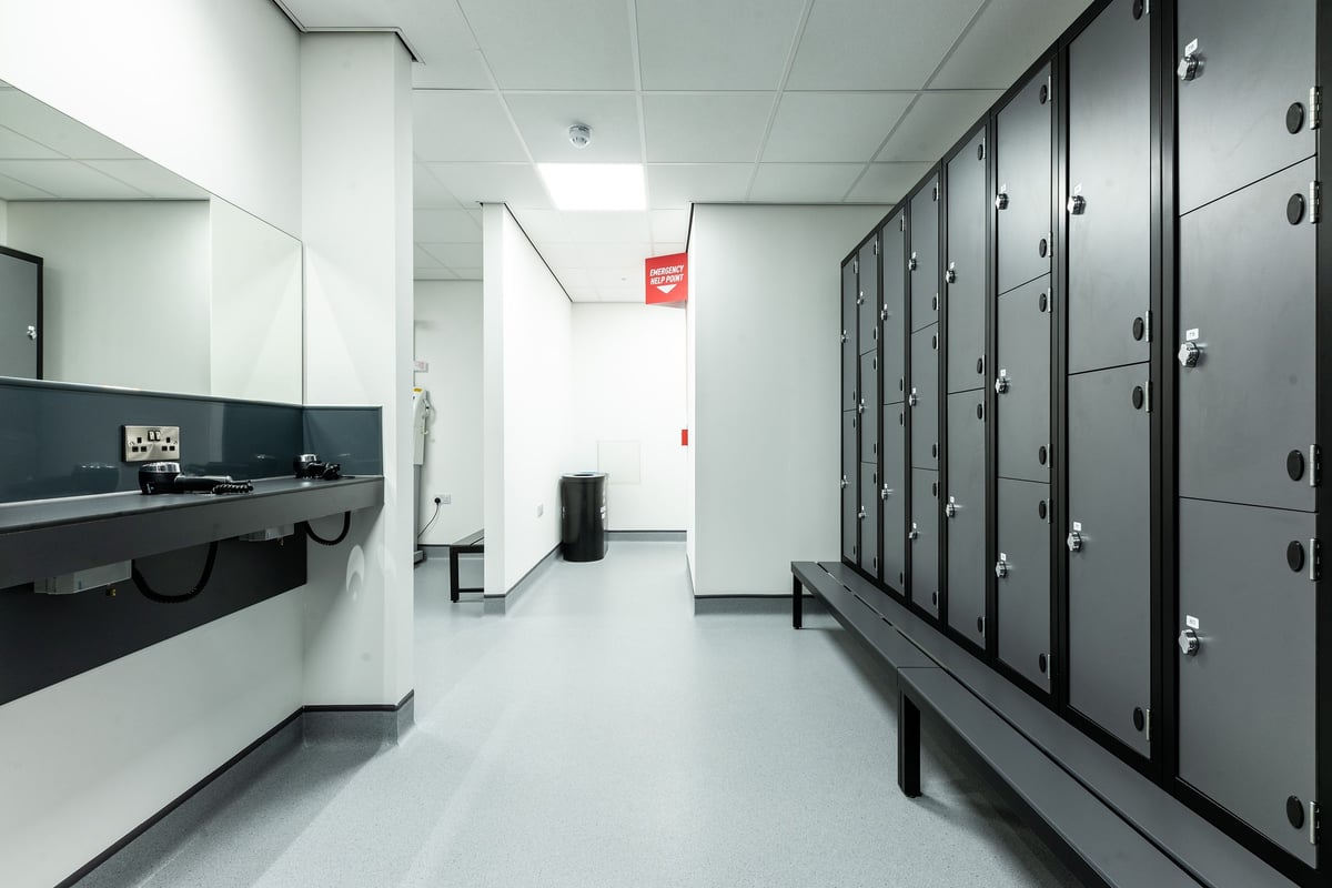 PureGym Boston: Rows of lockers, sinks, and benches in a utilitarian changing room setting.
