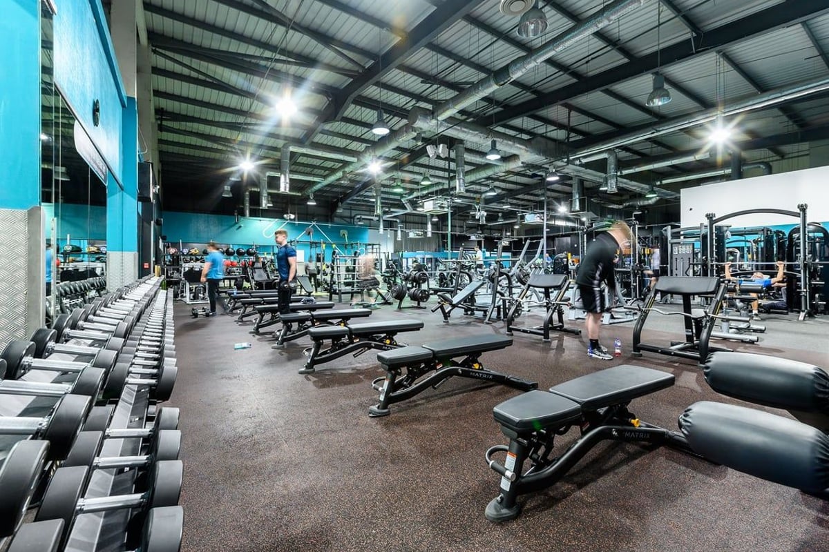 PureGym Bromborough: Weights benches, squat racks, dumbbells, weight plates, mirrors, and a spacious gym floor.