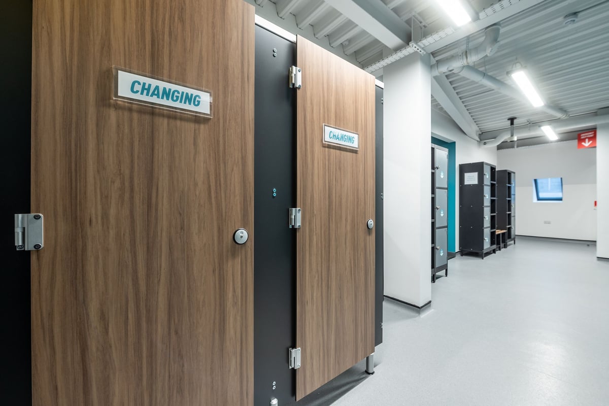 PureGym Brentwood: Changing rooms with wooden doors and signage indicating their purpose.
