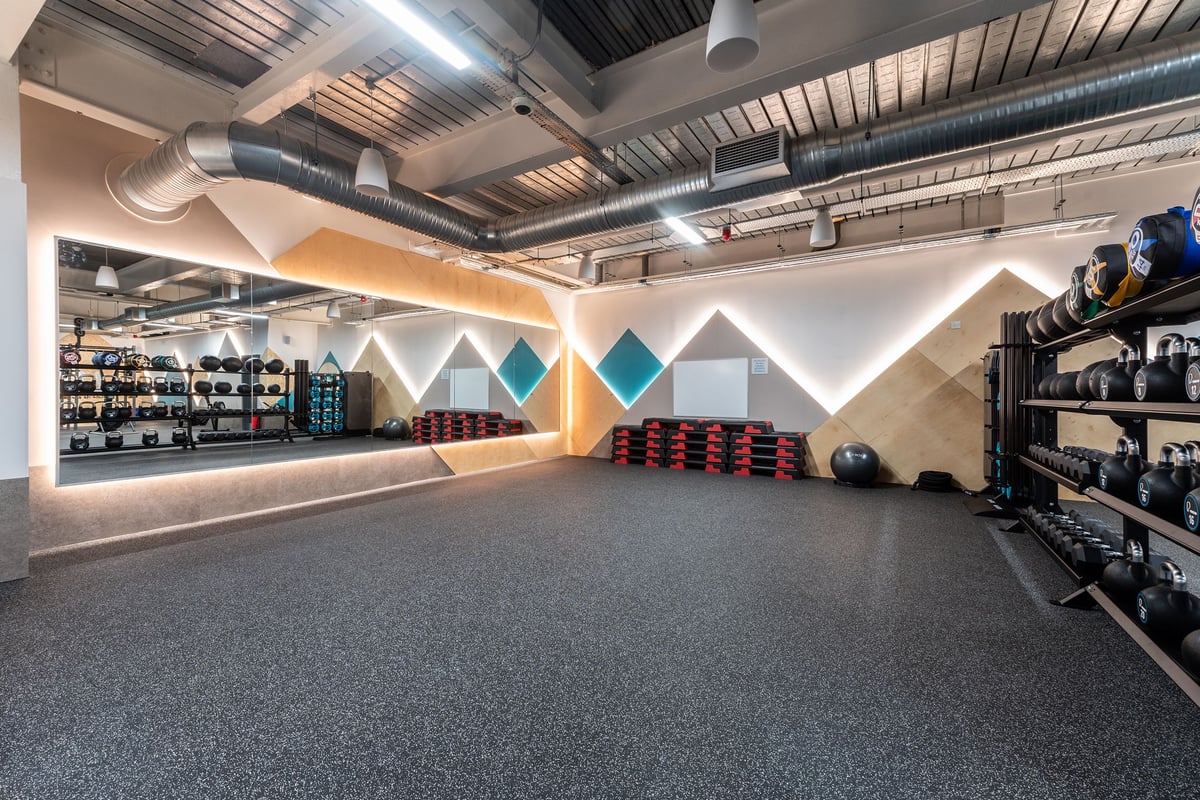 PureGym Droitwich Spa: Weight racks, mirrored walls, free weights, rubberized flooring in a gym studio.