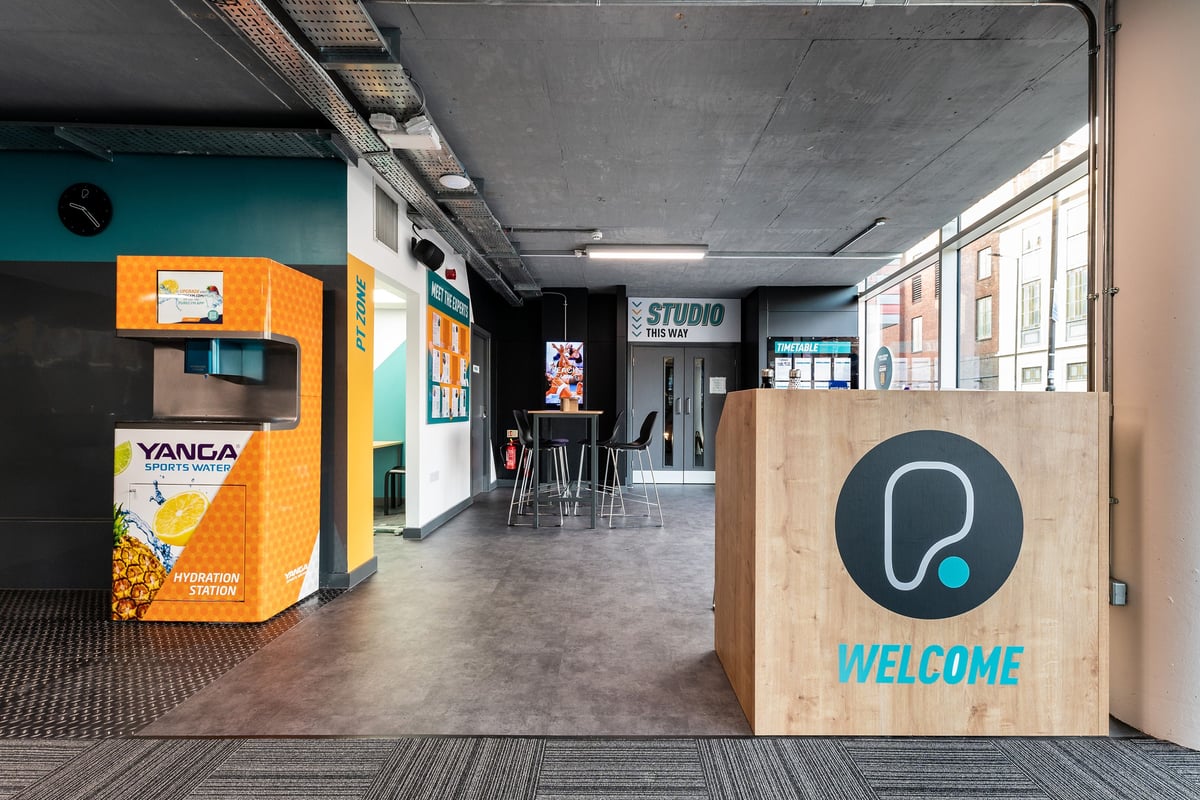 PureGym London Finsbury Park: Exercise studio with vending machine, stools, and welcome sign.