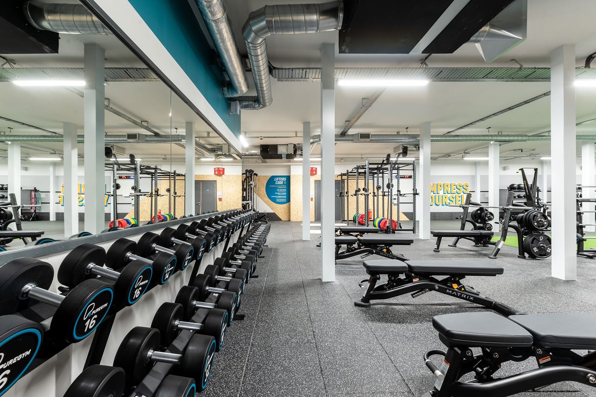 PureGym Northallerton: Rows of free weight benches, dumbbells, squat racks, and strength equipment in a gym setting.