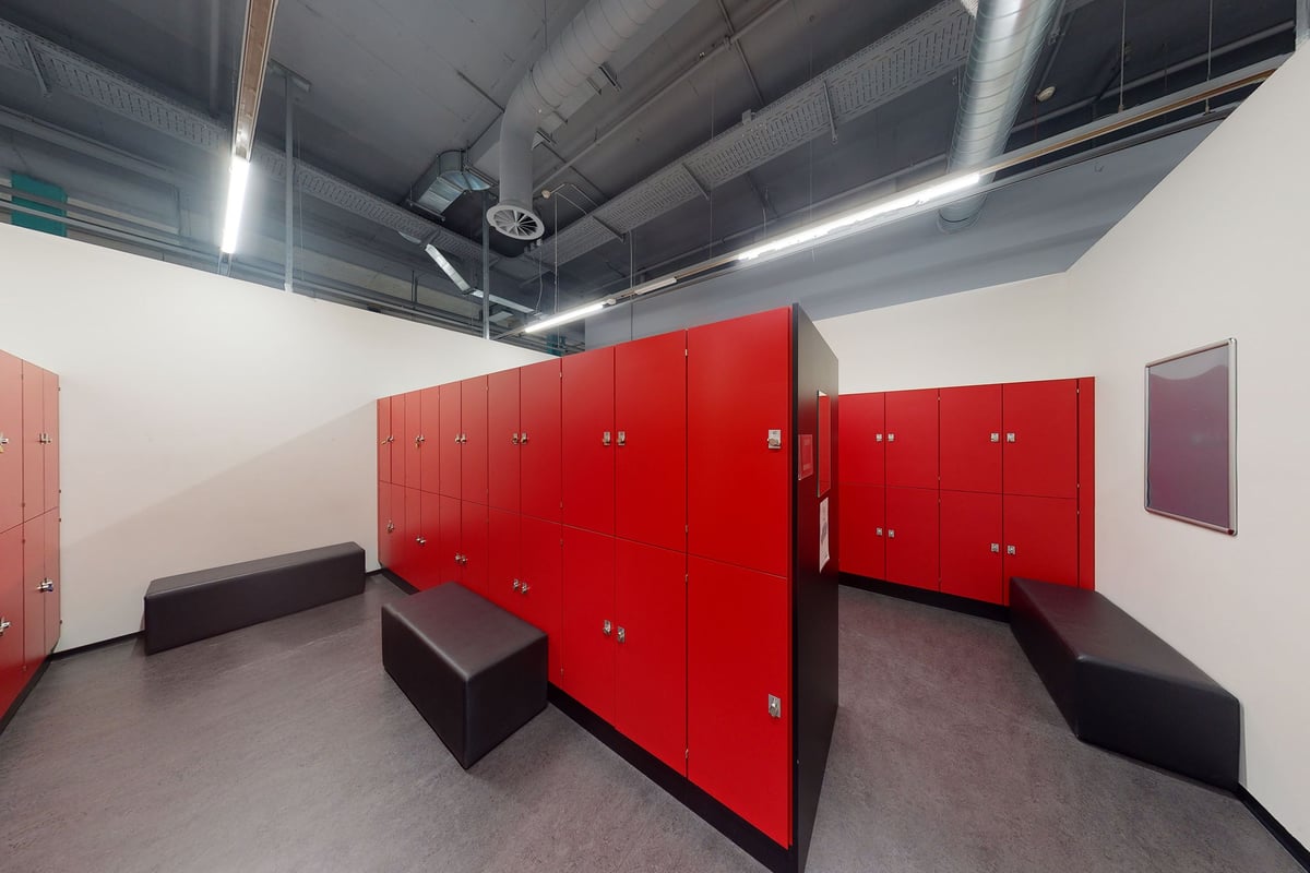 PureGym Winterthur Töss: Casiers et bancs rouges dans les vestiaires d'une salle de sport.