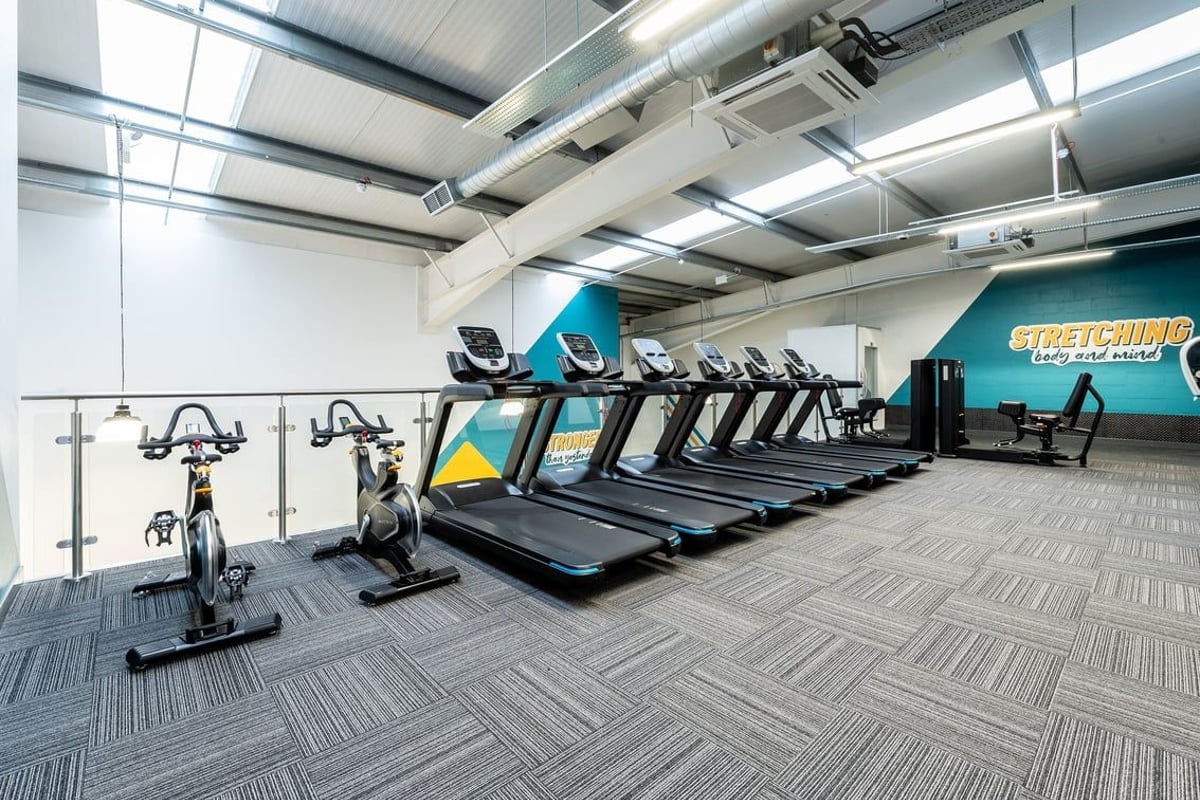 PureGym Inverness Inshes Retail Park: Rows of treadmills, stationary bikes, aircon ducting overhead in a bright gym studio.