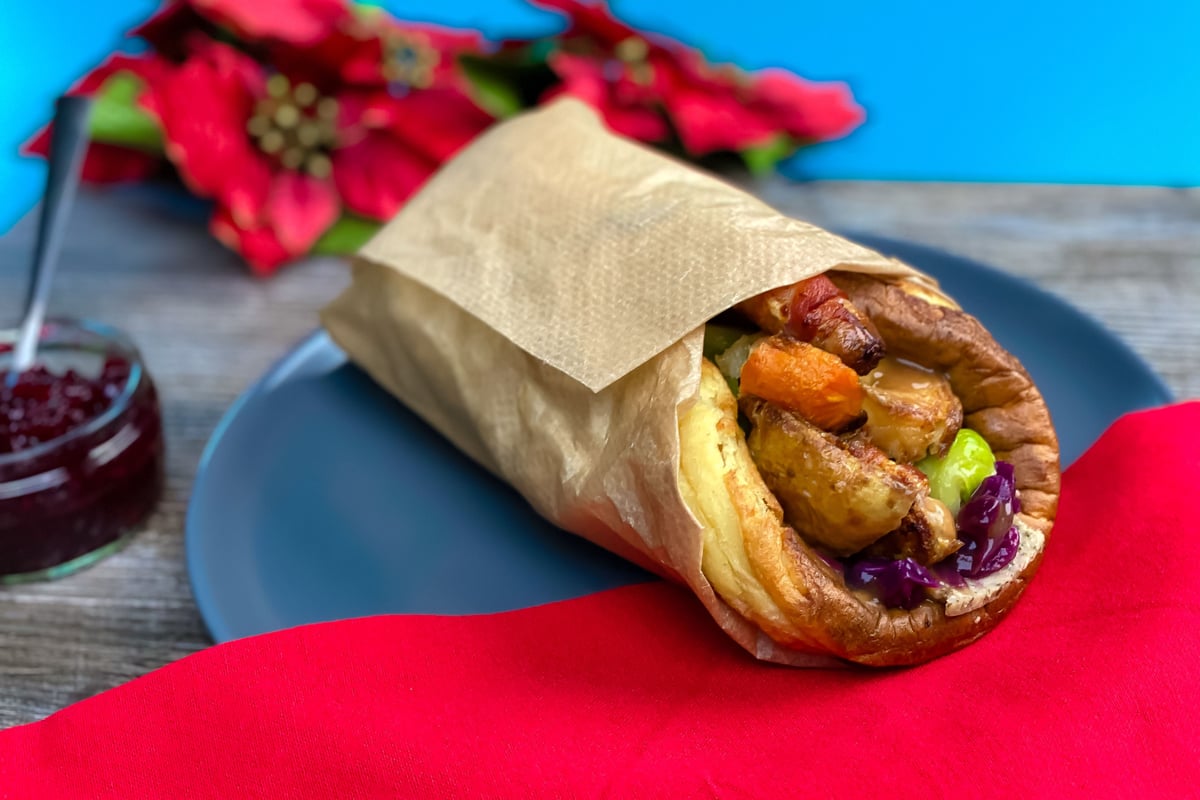 Yorkshire pudding wrap filled with roast vegetables on a blue plate with red cloth