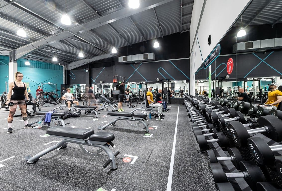 PureGym Warrington Central: Gym interior with weight machines, free weights, benches, and rubberized flooring visible.