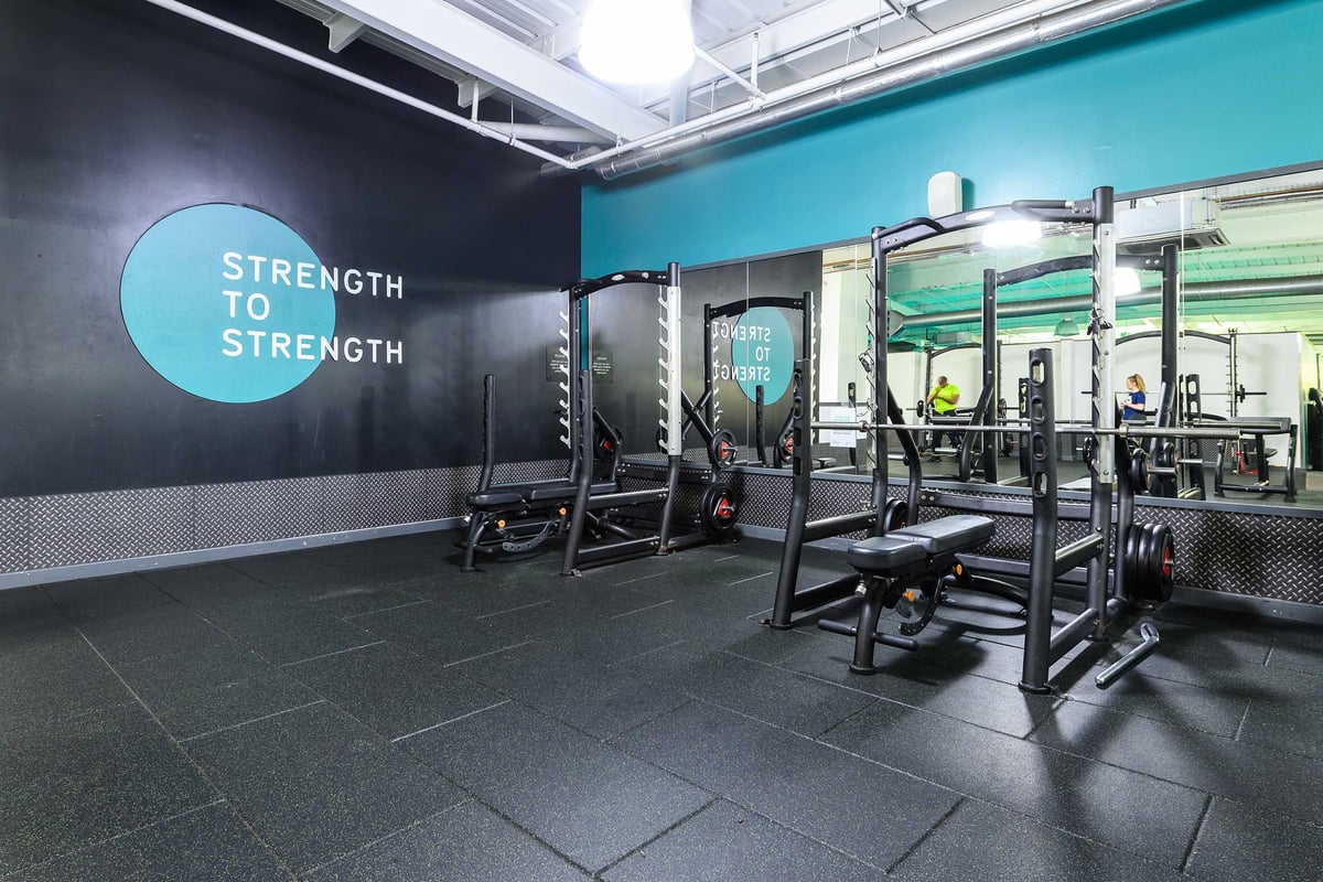 PureGym Glasgow Shawlands: Resistance equipment, benches on rubberised flooring in spacious gym.