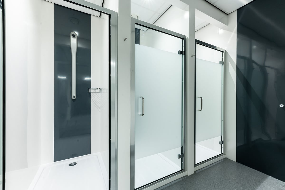 PureGym Boston: Glass shower stalls with handles, floors with non-slip surfaces.