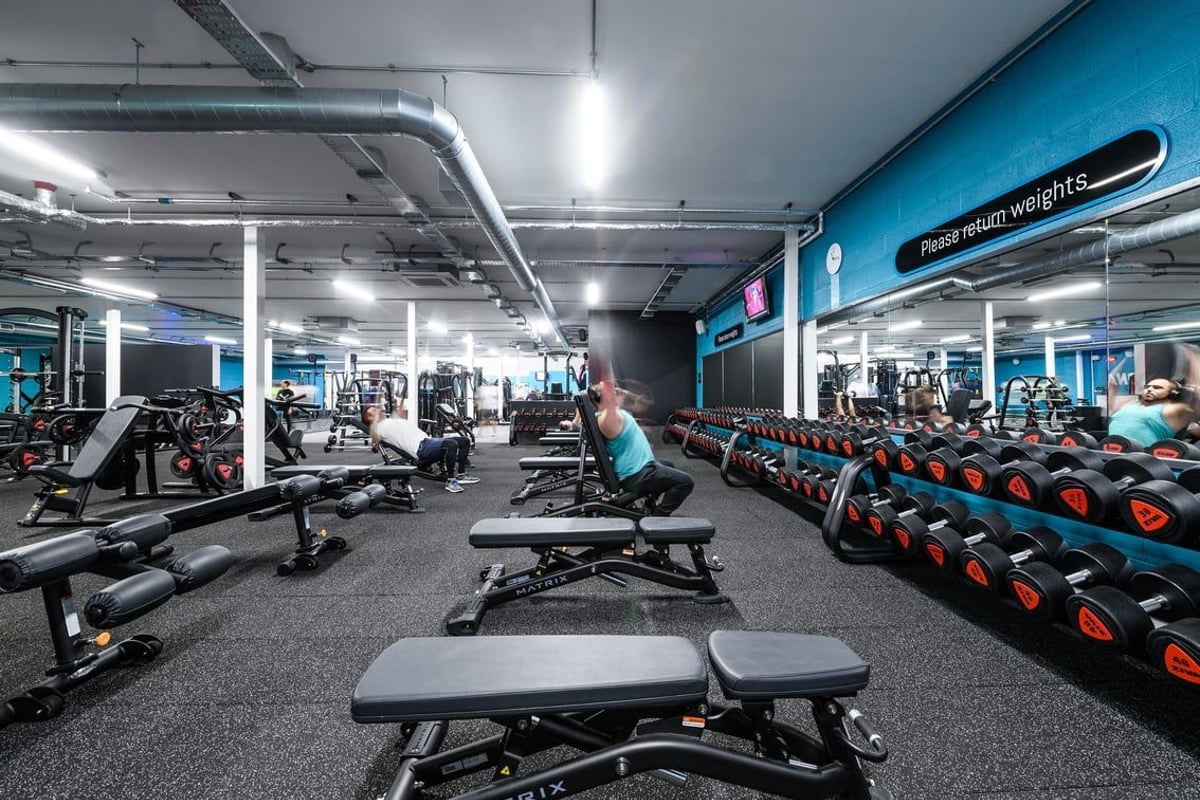 PureGym Cardiff Bay: Treadmills, weightlifting benches, free weights, resistance machines in turquoise and grey color scheme.
