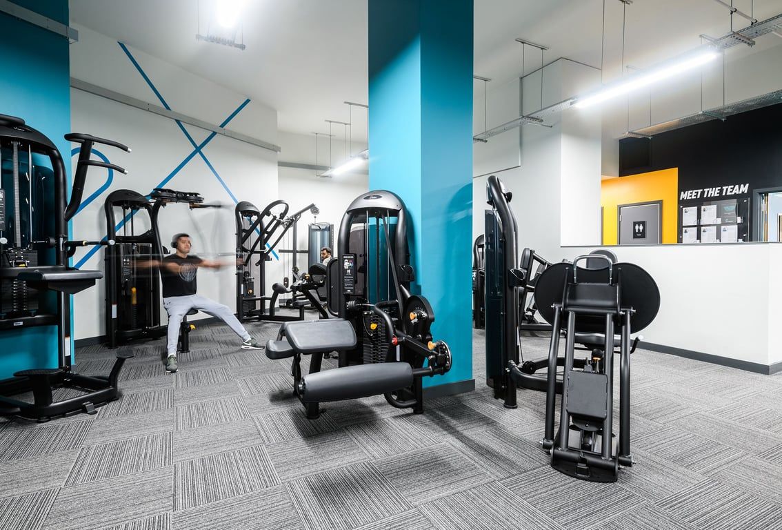 PureGym London Whitechapel: Multiple resistance machines, cable pulleys, benches, and weight racks in a modern gym space.