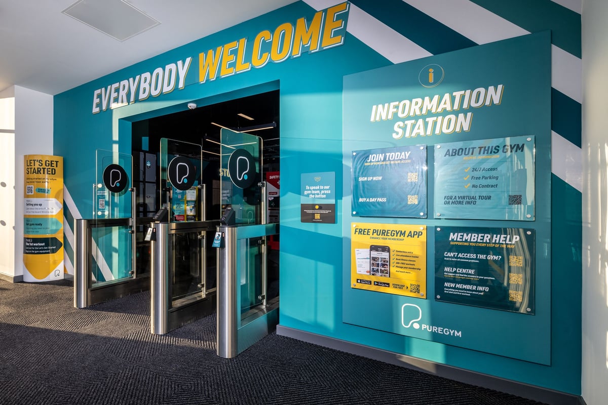 PureGym Hull Clough Road: The gym entrance with turnstiles, information desk, and signage welcoming members.