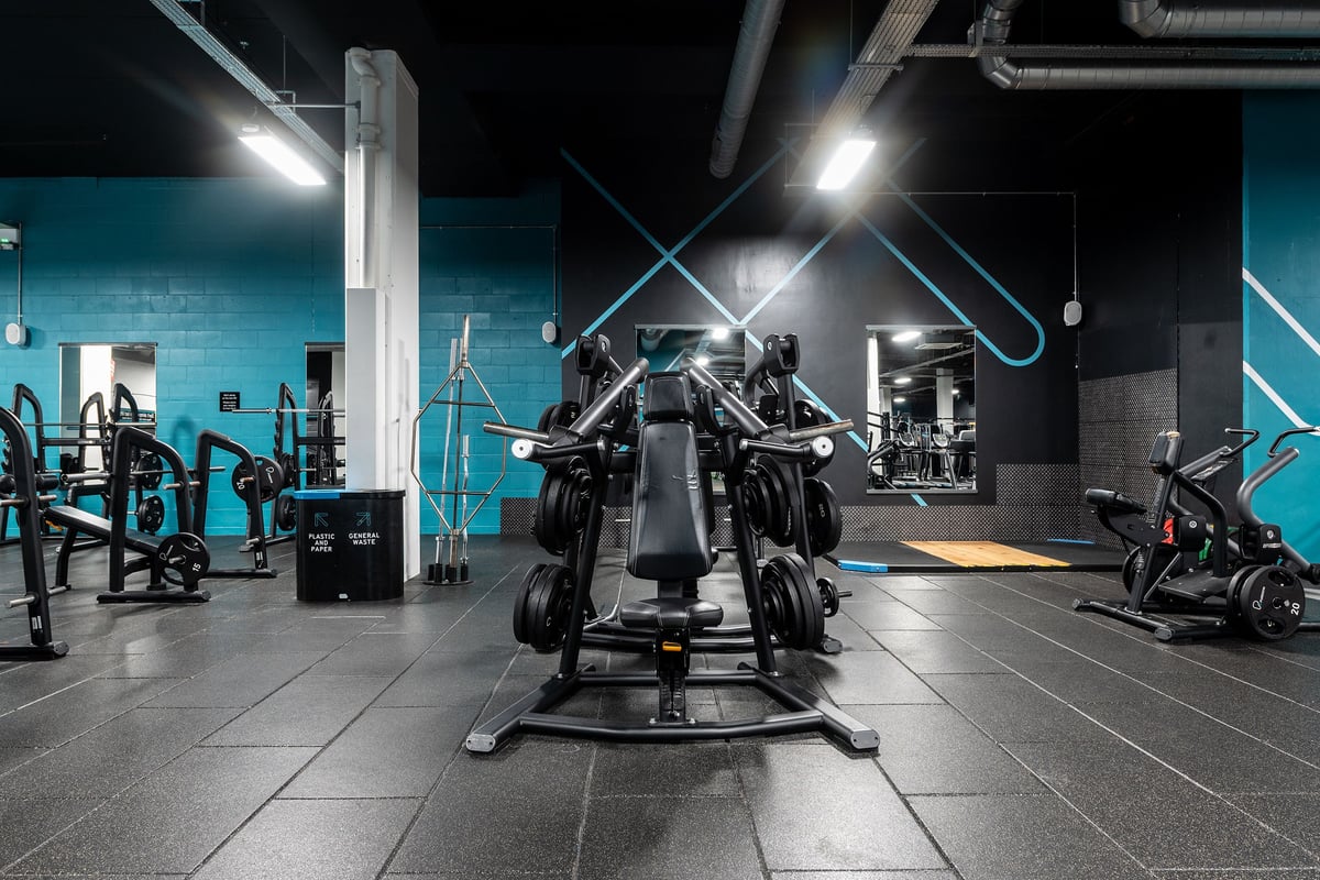 PureGym Norwich Castle Mall: Gym interior with weight machines, squat racks, free weights, benches, and teal accent walls.
