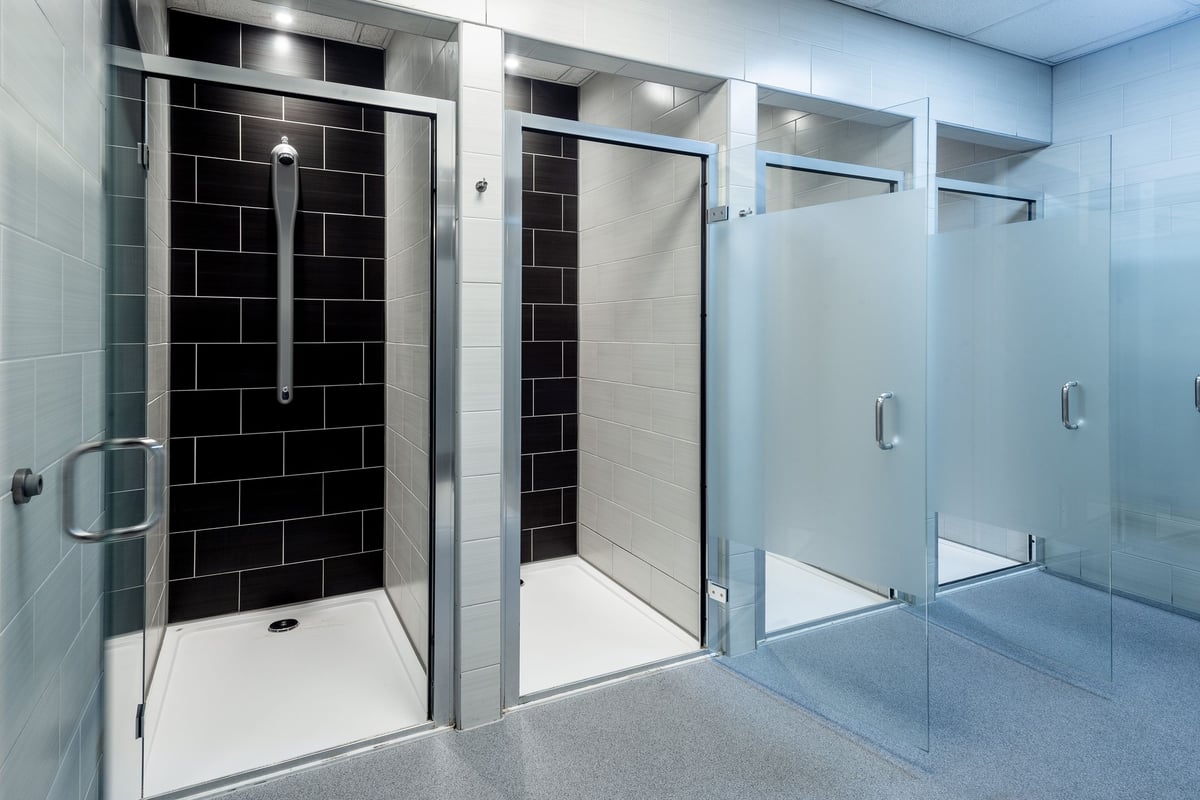 PureGym Leicester St Georges Way: Contemporary shower stalls with glass doors, tiled walls, and tiled flooring.