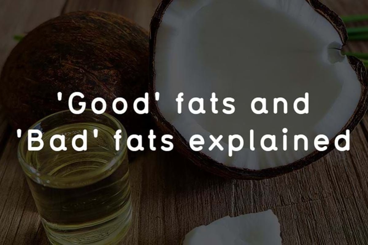 Half coconut, coconut oil in glass, and text about good and bad fats on wooden table