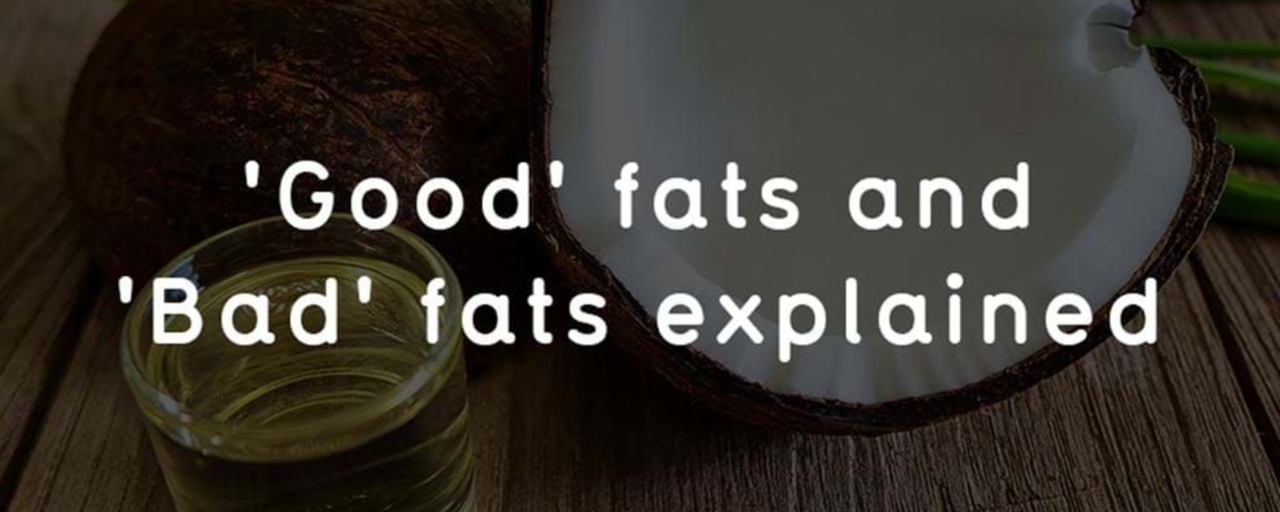 Half coconut, coconut oil in glass, and text about good and bad fats on wooden table