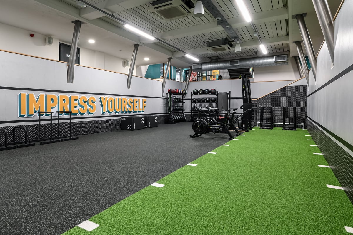 PureGym London Piccadilly: Weight racks, turf area, resistance machines, wall mirrors, motivational signage.