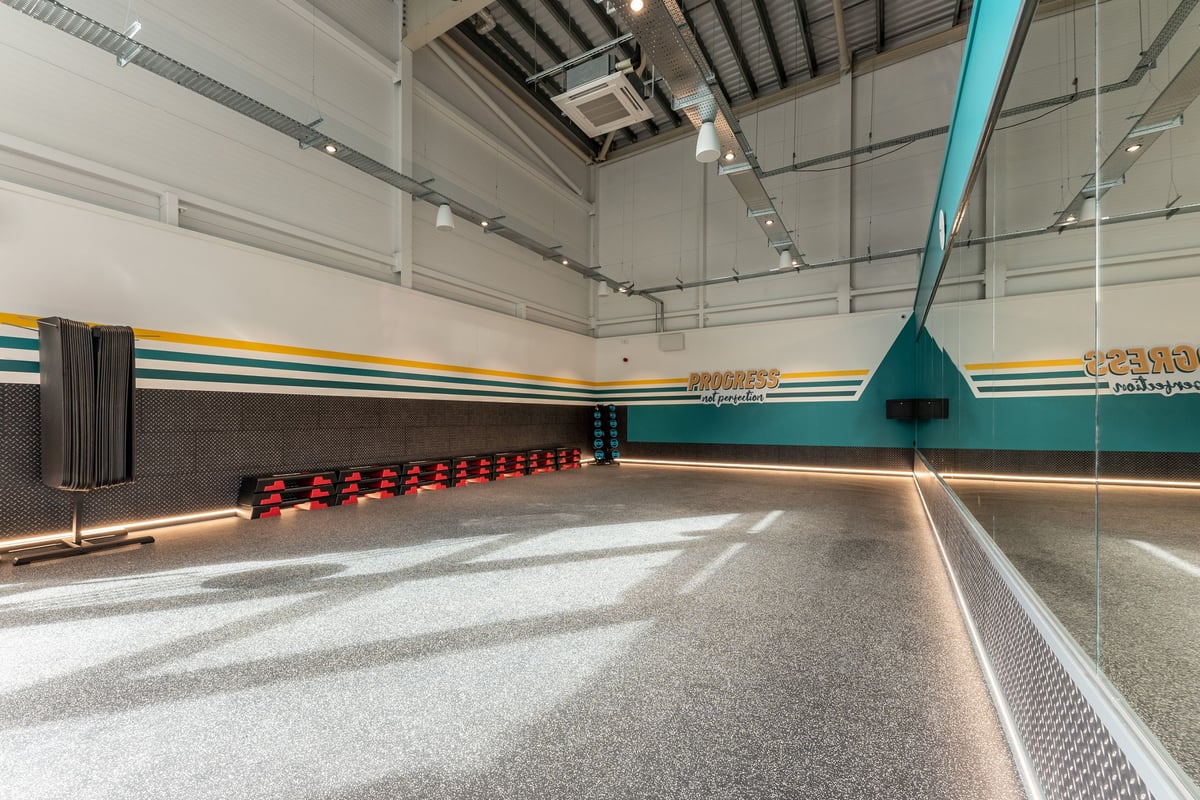 PureGym St Ives Cambridgeshire: Studio with training matts and stacks of step platforms opposite a mirrored wall.