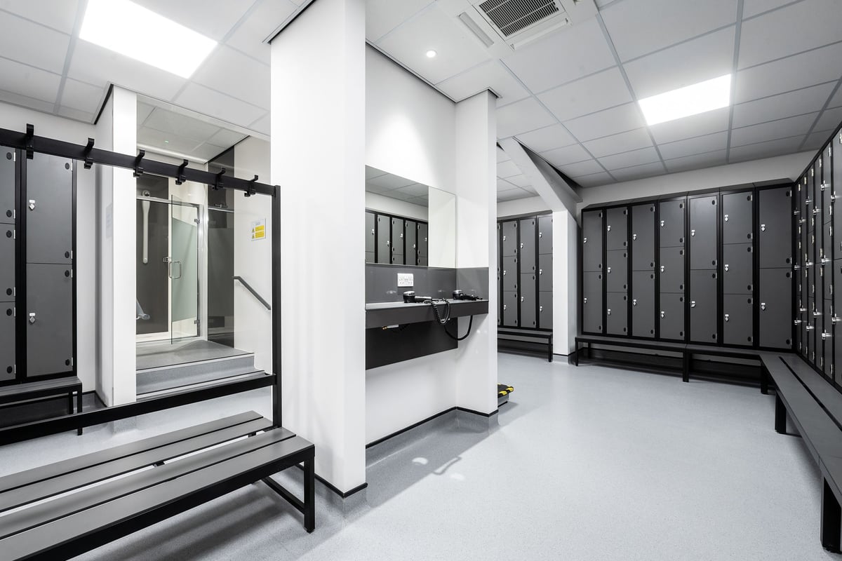 PureGym Cheshunt Brookfield Shopping Park: Rows of locker units, benches, and a sink area in a changing room setting.