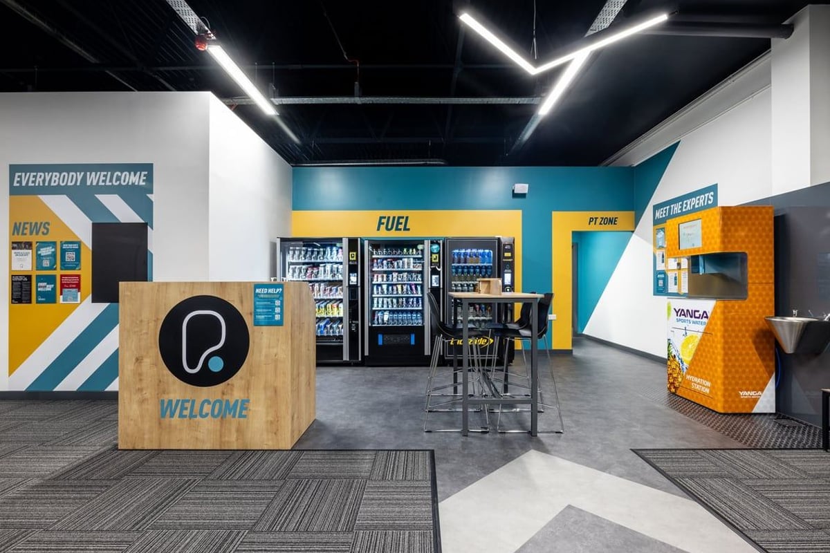 PureGym Washington: Welcome desk, fuel vending machines, seating area, bright colour accents.
