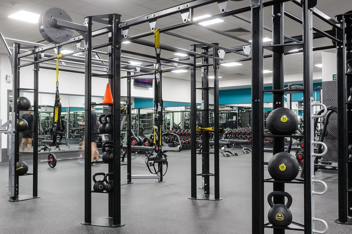 PureGym Glasgow Bath Street: Rig frames, weight plates, kettlebells, rubberized flooring in a functional training space.