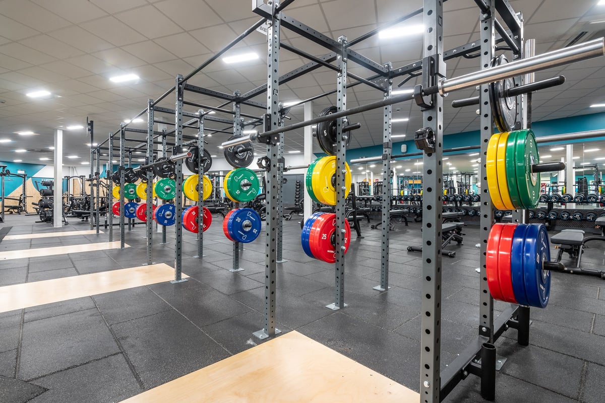 PureGym Aberdeen Kittybrewster: Racks with colourful weight plates, free weights, benches, and rubberized floors.
