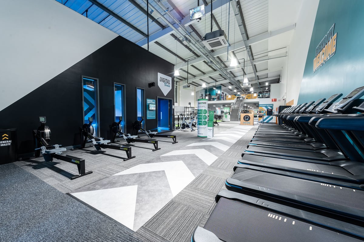 PureGym Torquay Bridge Retail Park: Rows of treadmills, weight racks, black framing, neon lighting dÃ©cor.