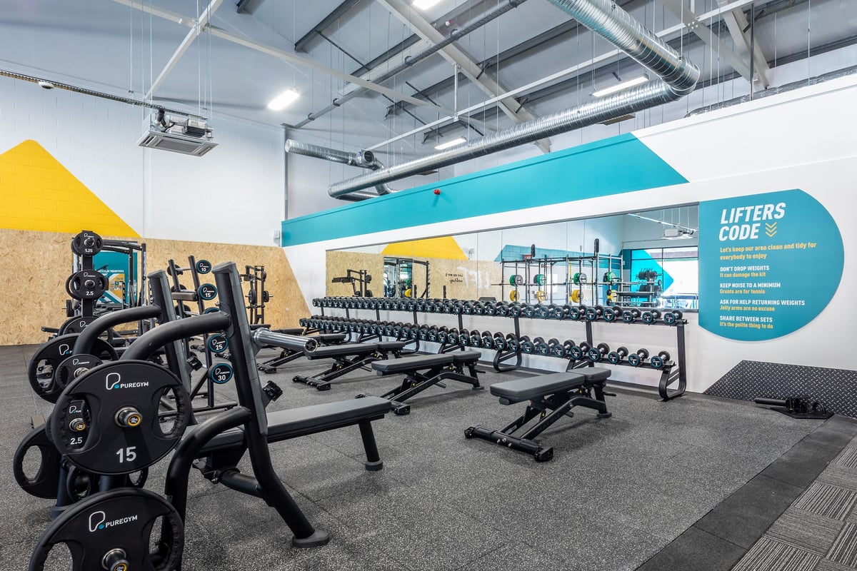 PureGym Ebbw Vale: Rows of weight benches, free weights, resistance machines, and rubberized flooring in a gym area.
