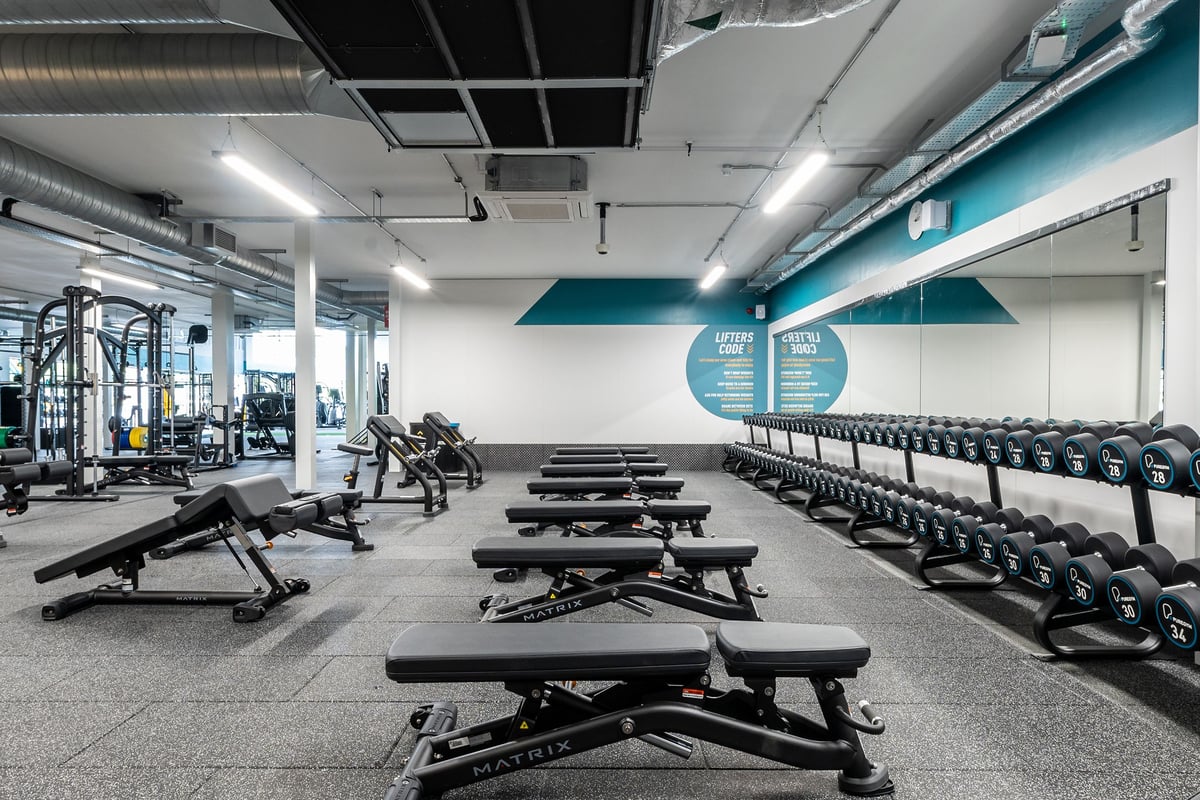 PureGym Doncaster: Rows of weight benches, dumbbell racks, and exercise equipment on rubberized flooring.