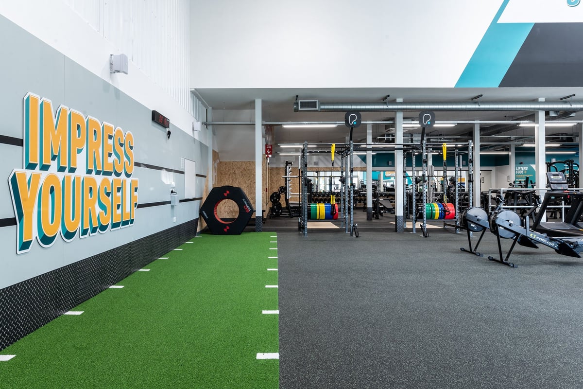 PureGym Grantham Discovery Retail Park: Gym with weight racks, turf area, free weights, and motivational wall graphics.