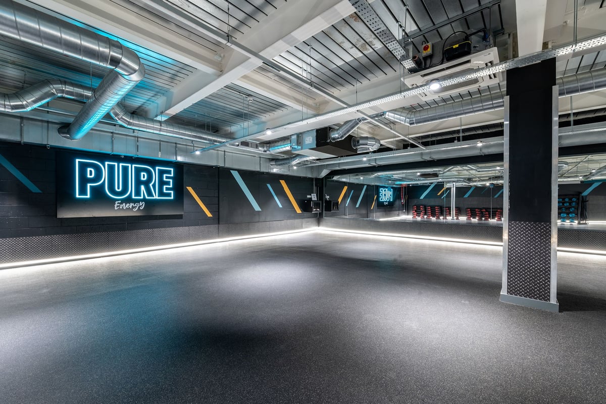 PureGym London Orpington Central: Studio with neon lighting, treadmill tracks and the word "PURE" prominently displayed.