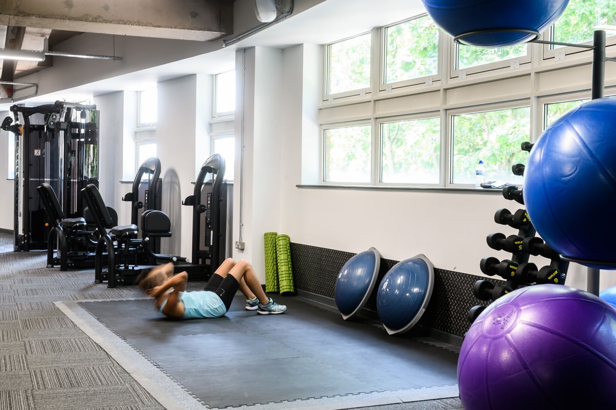 PureGym Birmingham Arcadian Centre: Weight machines, exercise balls, resistance bands, and mirrored wall in gym setting.