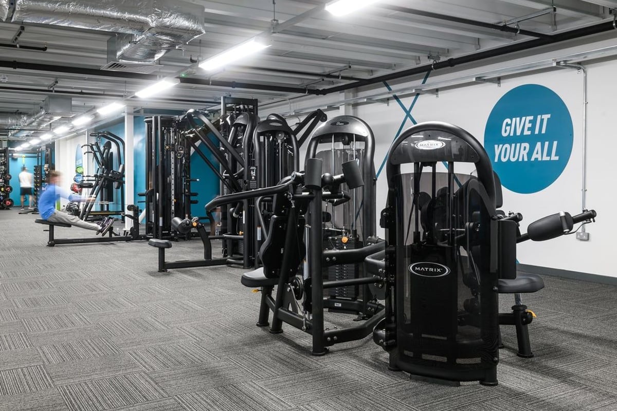 PureGym Glasgow Silverburn: Cable machines, weight stacks, benches, and rubberized flooring in a gym studio.