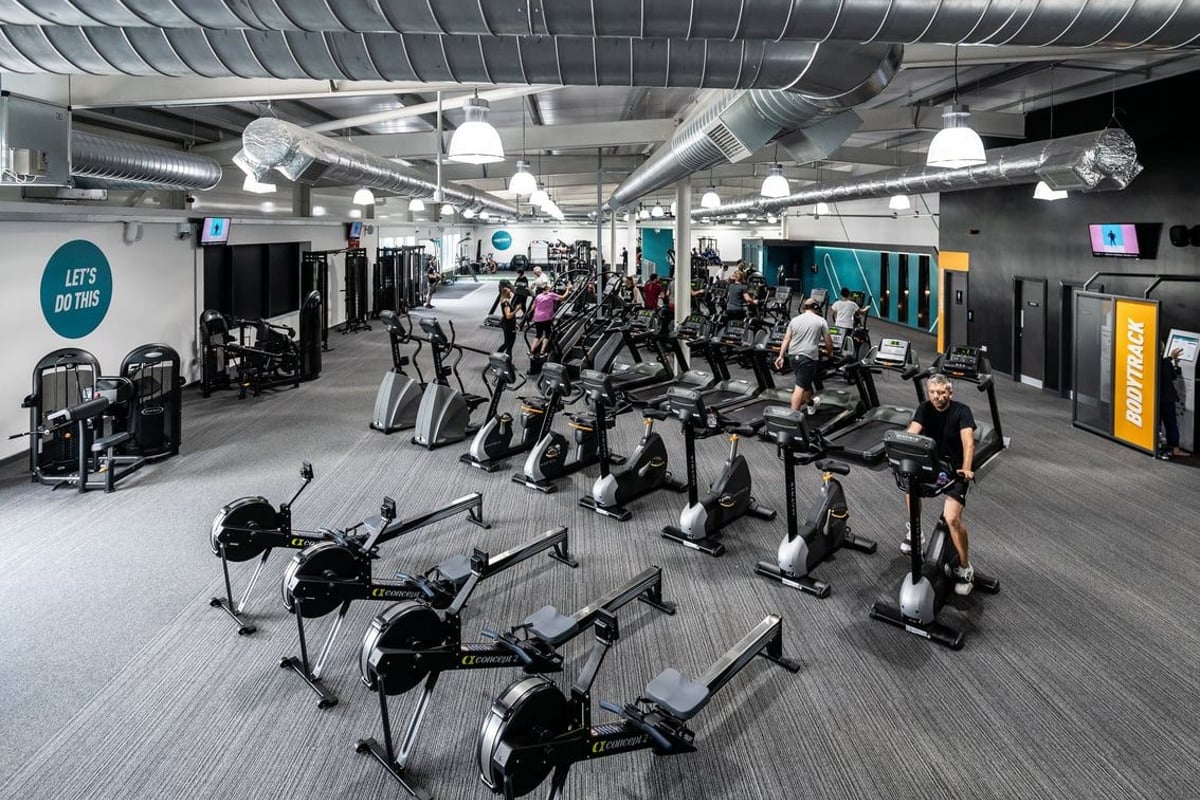 PureGym Portsmouth North Harbour: Rows of upright exercise bikes, ellipticals, and treadmills in a modern fitness studio.