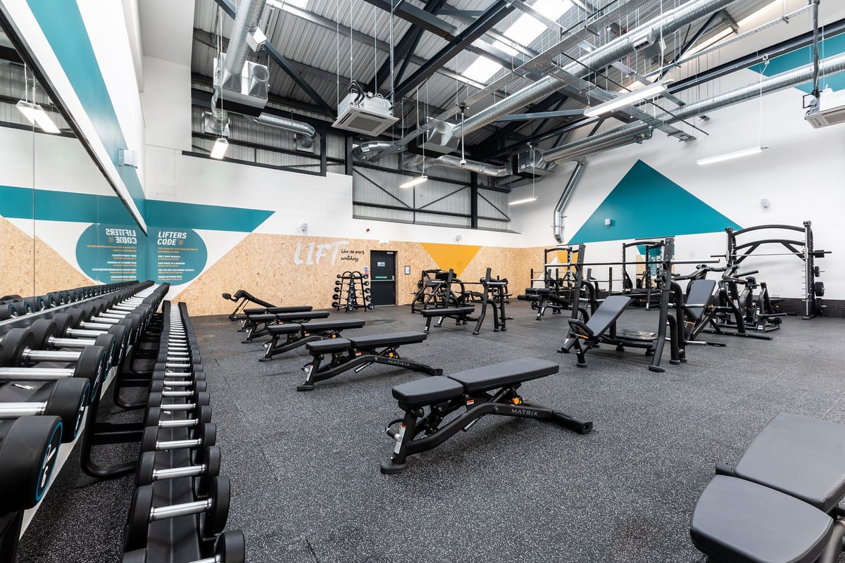 PureGym Southport: Weight benches, free weights, rubberized floors, and exercise equipment in a gym studio.