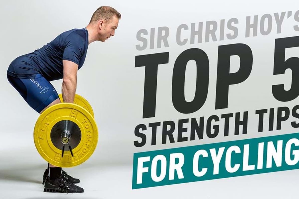 Man in cycling gear lifting a barbell with yellow weights against white background