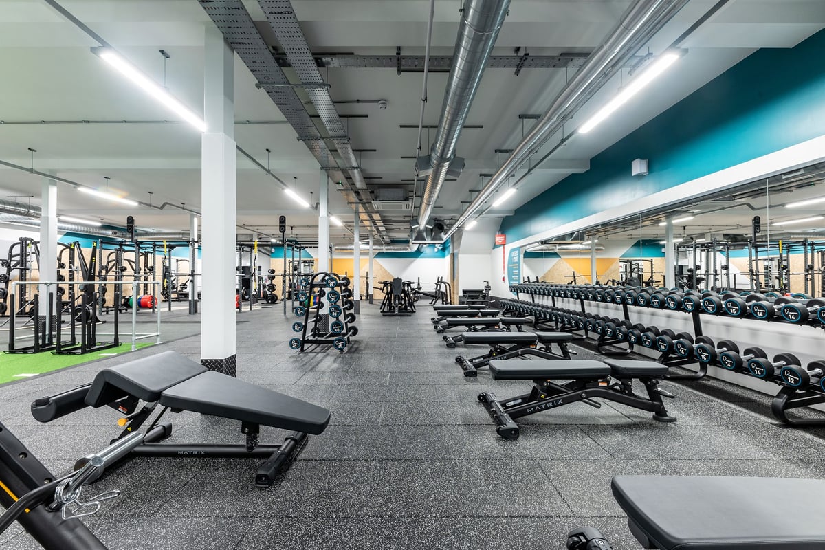 PureGym Shrewsbury Meole Brace: Weight benches, racks, dumbbells, and rubberized floors in a brightly lit gym space.