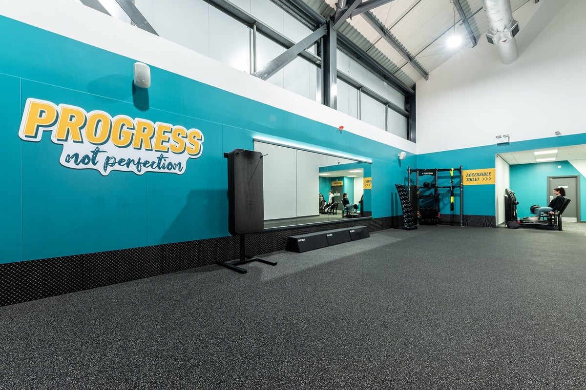 PureGym Chatham: Treadmills, resistance machines, rubberized flooring, and inspirational murals in teal and orange.