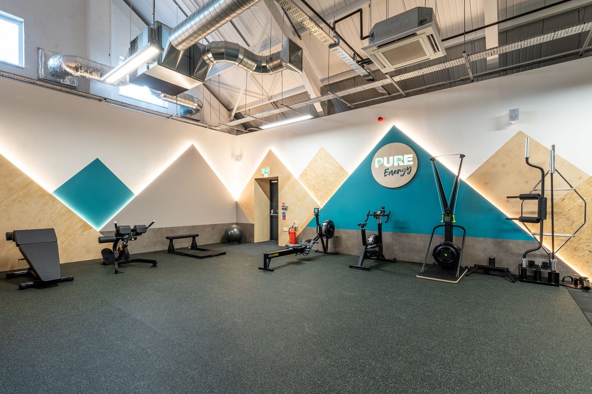 PureGym Kendal: Fitness studio with weightlifting platforms, squat racks, benches, and rubberised flooring.