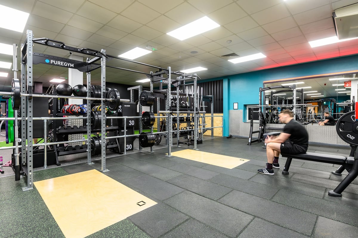 PureGym Waterlooville: Racking, benches, weights, platforms, functional training zone with rubberized flooring.