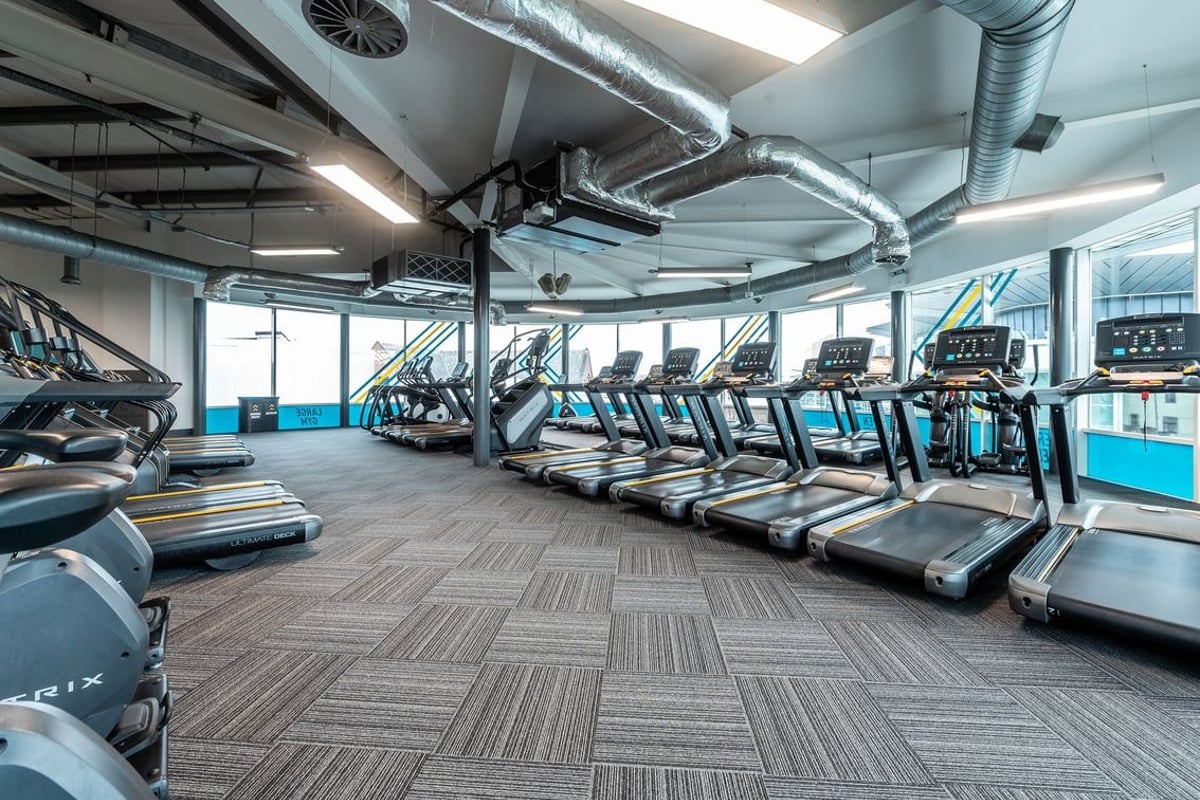 PureGym Loughborough: Rows of treadmills, exposed ducts and vents in a modern gym facility.