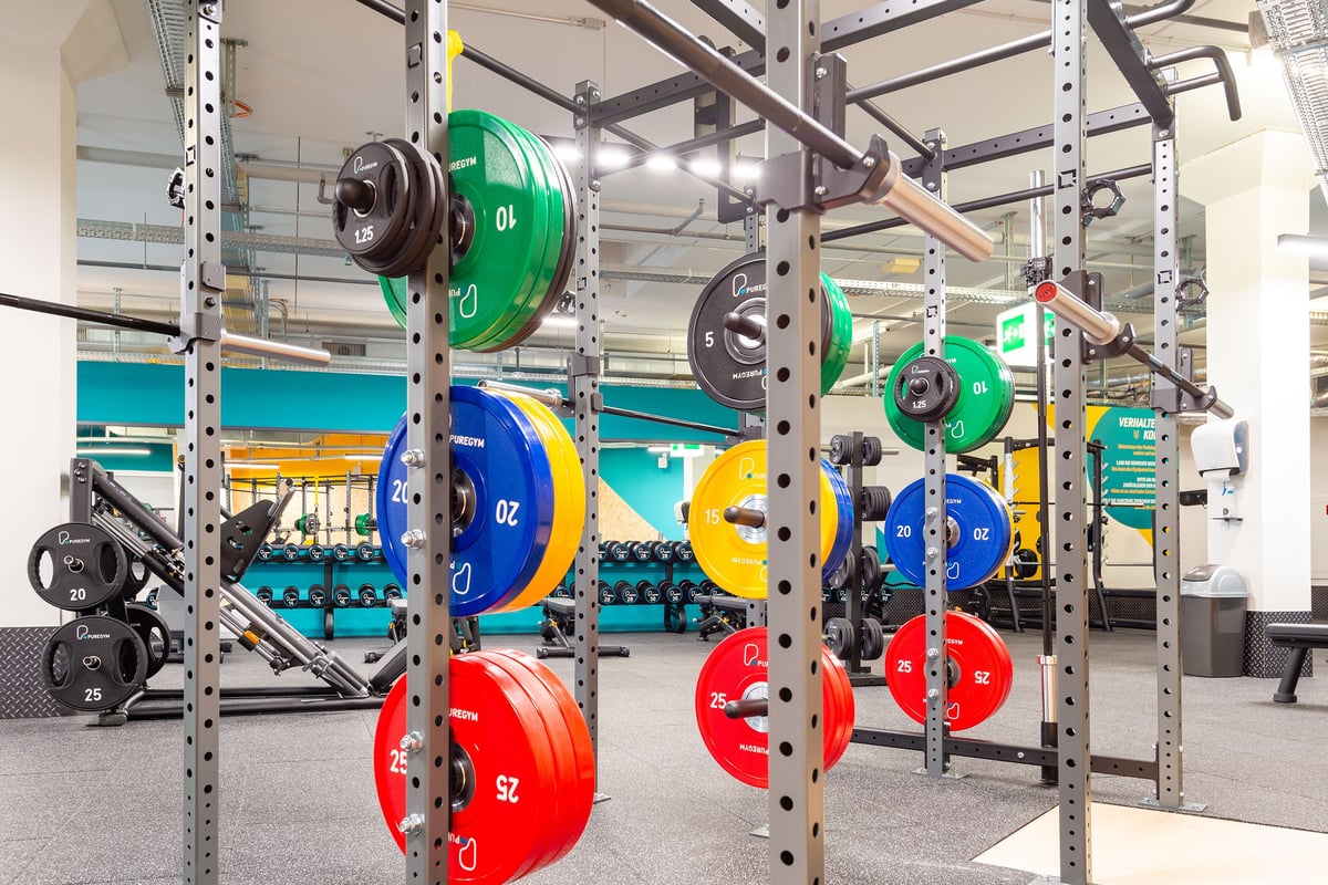 PureGym Wil: Supports avec plaques de poids colorées en vert, bleu, jaune et rouge.